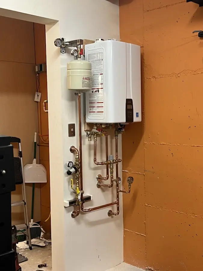 Plumbing technician inspecting water heater connections in Tyler